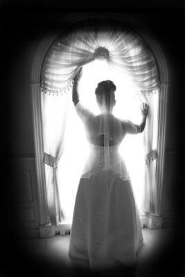 Magazine style fashion photoshoot in Los Angeles. Portrait of the Bride looking out the window. Photo shows her wedding dress and veil.