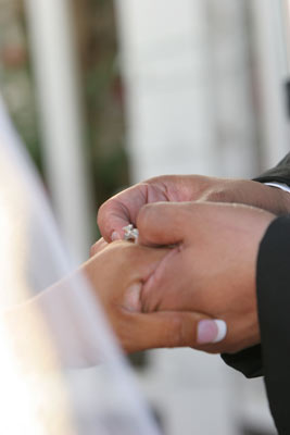 Photography of a wedding ring being place on the brides finger at a Santa Barbara wedding location.