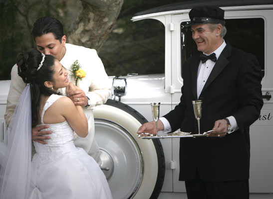 Photojournalistic photo of a wedding in Los Angeles with an old classic car limousine and schofer with champaign