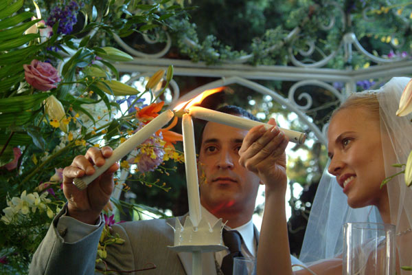 Bride and Groom light the unity candle in this photojournalistic image. Taken at a Los Angeles ceremony/reception location.